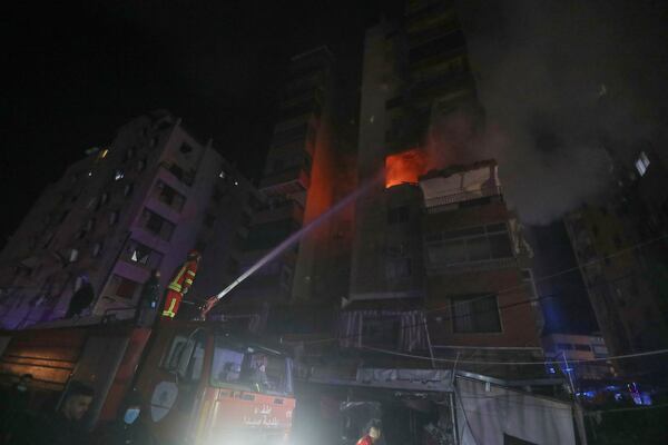 A firefighter extinguishes the flames inside an apartment that was hit by an apparent Israeli airstrike, in the southern port city of Sidon, Lebanon, early Friday, April 4, 2025. (AP Photo/Mohammed Zaatari)
