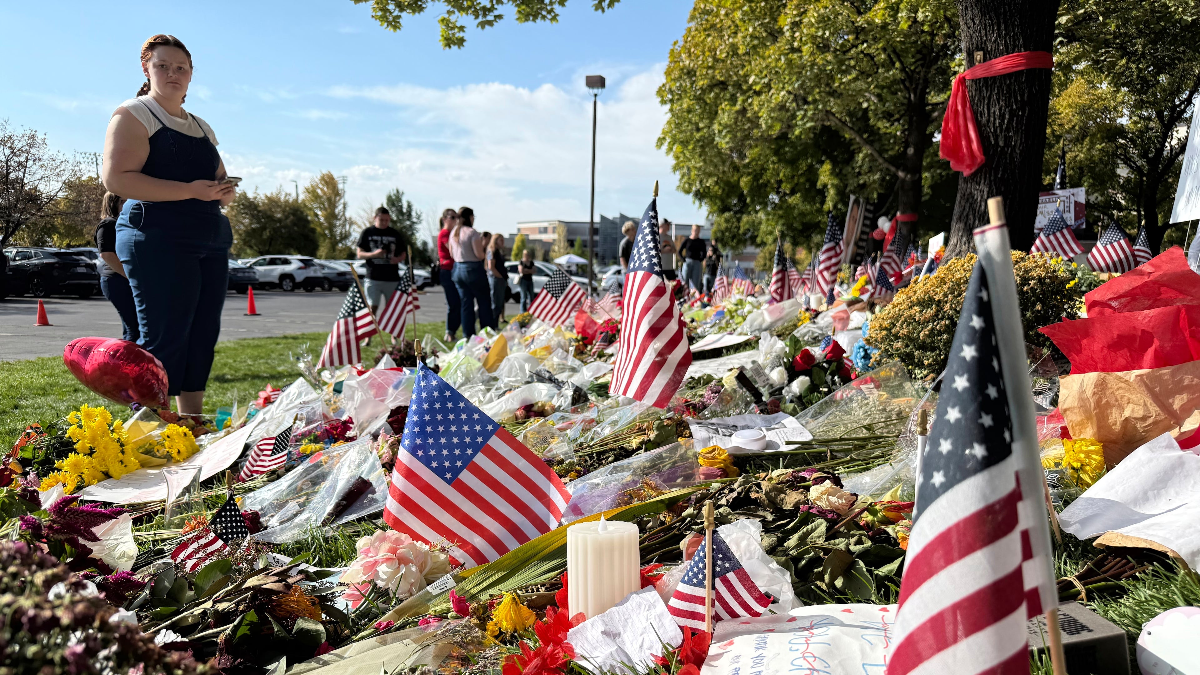 American flags and flowers are displayed at a memorial for Charlie Kirk at Utah Valley University, Monday, Sept. 15, 2025, in Orem, Utah. (AP Photo/Jesse Bedayn)