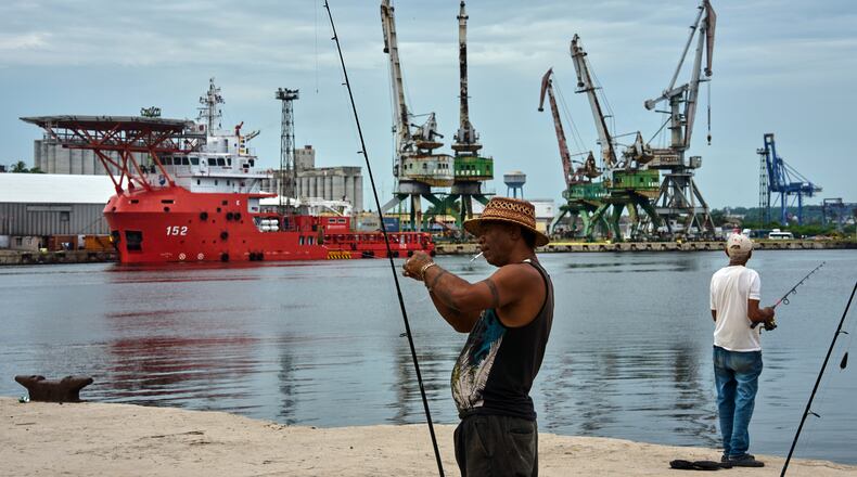 A fisherman prepares his fishing rod in front of the Colombian Navy ship ARC Caribe, docked at a pier in Havana, Cuba, after arriving with humanitarian aid, Friday, June 12, 2926. (AP Photo/Ramon Espinosa)