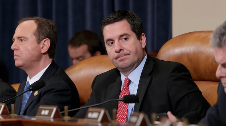 FILE- In this March 20, 2017, file photo, House Intelligence Committee Chairman Rep. Devin Nunes, R-Calif., center, flanked by the committee's ranking member Rep. Adam Schiff, D-Calif., left, and Rep. Peter King, R-N.Y., listens on Capitol Hill in Washington during the committee's hearing on allegations of Russian interference in the 2016 U.S. presidential election. Two weeks after President Donald Trump blocked its full release, the House Intelligence Committee published on Saturday, Feb. 24, 2018, a partially blacked-out version of a classified Democratic memo aiming to counter a GOP narrative that the FBI and Justice Department conspired against Trump as they investigated his ties to Russia. (AP Photo/J. Scott Applewhite, File)
