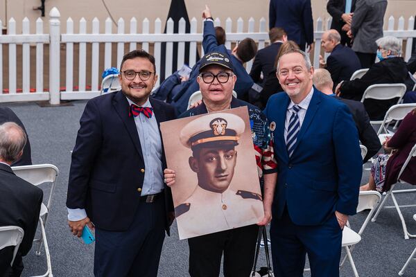 David Campos, left, vice chair of the California Democratic Party, Nicole Murray-Ramirez, middle, an LGBT activist, holding a photo of Harvey Milk, and Bevan Dufty director of the San Francisco Bay area rapid transit district, pose for a photo before the launching of the USNS Harvey Milk in San Diego on Saturday.