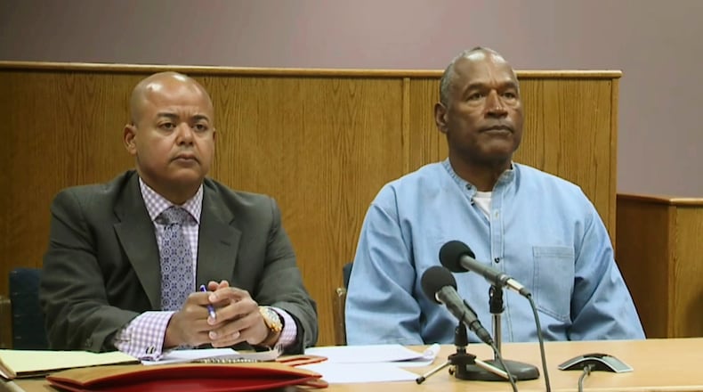 Former NFL football star O.J. Simpson appears with his attorney, Malcolm LaVergne, left, via video for his parole hearing at the Lovelock Correctional Center in Lovelock, Nev., on Thursday, July 20, 2017.  Simpson was convicted in 2008 of enlisting some men he barely knew, including two who had guns, to retrieve from two sports collectibles sellers some items that Simpson said were stolen from him a decade earlier. (Lovelock Correctional Center via AP)