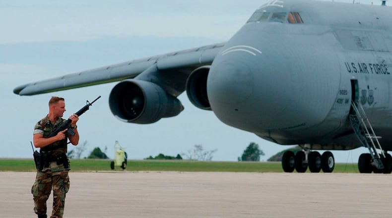 U.S. Navy security officer Andrew Charman stands watch near an Air Force C-5 Galaxy transport aircraft at the U.S. Naval Base at Guantanamo Bay on Jan. 10, 2002.