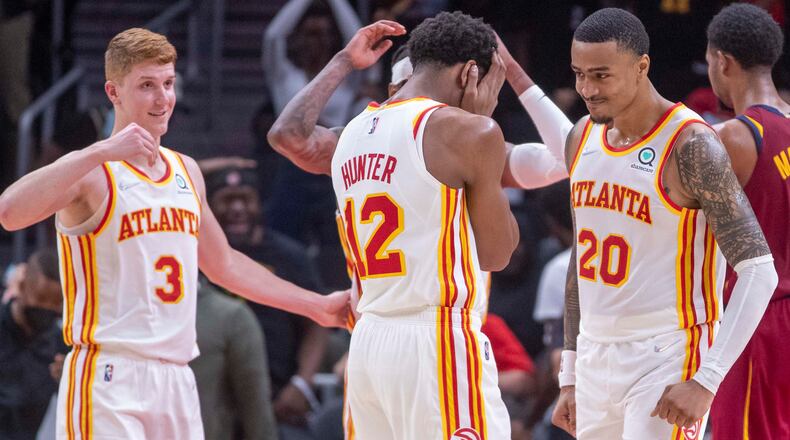 Hawks forward John Collins (20) and his teammates react after a Collins dunk during a preseason game at State Farm Arena.