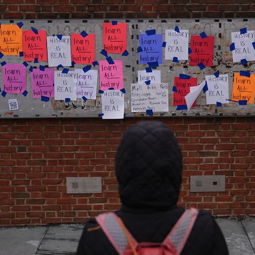 A person views posted signs on the locations of the now removed explanatory panels that were part of an exhibit on slavery at President's House Site in Philadelphia, Friday, Jan. 23, 2026. (AP Photo/Matt Rourke)