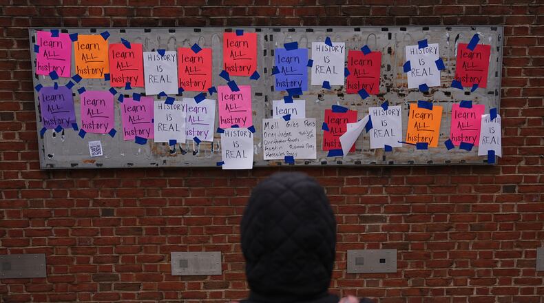 A person views posted signs on the locations of the now removed explanatory panels that were part of an exhibit on slavery at President's House Site in Philadelphia, Friday, Jan. 23, 2026. (AP Photo/Matt Rourke)
