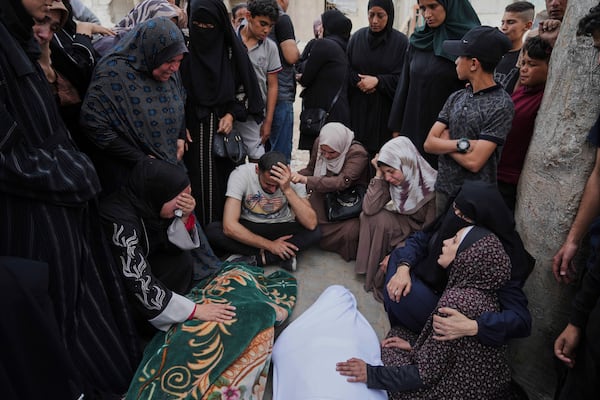 Relatives grieve over the bodies of members of the Jalis and Al-Sharbasi families, killed in an Israeli army airstrike on Yaffa School in Gaza City, Wednesday, April 23, 2025. (AP Photo/Jehad Alshrafi)