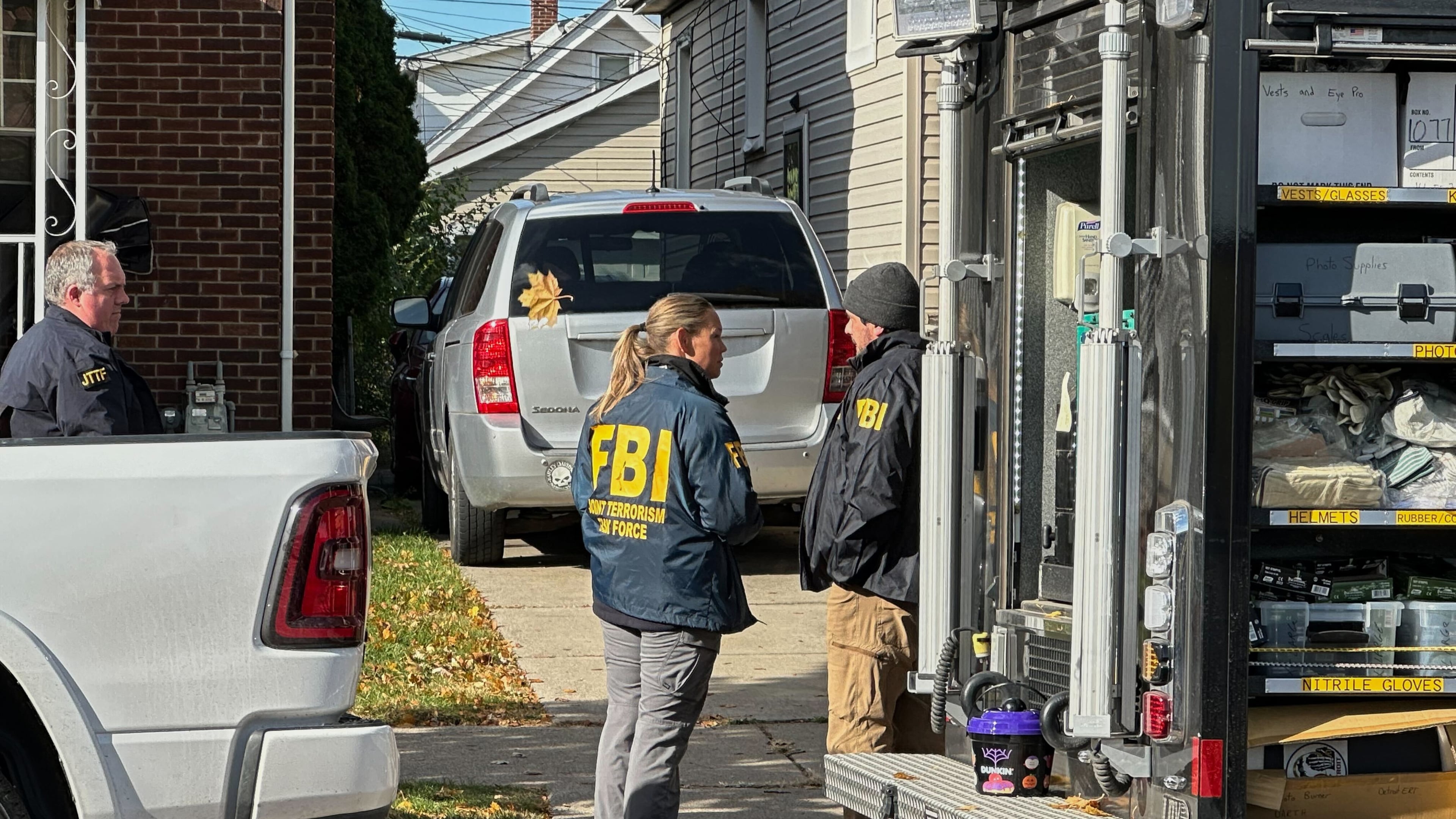 FBI agents gather outside a home in a Dearborn, Mich., neighborhood on Friday, Oct. 31, 2025. (AP Photo/Mike Householder)