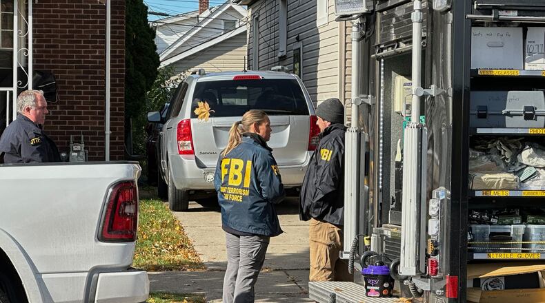 FBI agents gather outside a home in a Dearborn, Mich., neighborhood on Friday, Oct. 31, 2025. (AP Photo/Mike Householder)