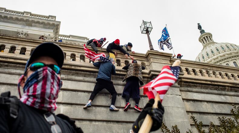 Supporters of President Donald Trump scale a wall on the Senate side of the Capitol Building in an attempt to disrupt the certification of the Electoral College results, Jan. 6, 2021. Poor planning among a constellation of government agencies and a restive crowd encouraged by President Trump set the stage for the unthinkable.(Jason Andrew/The New York Times)