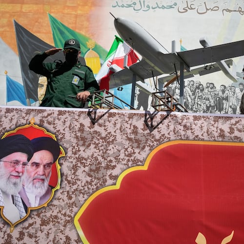 A member of Iran's Revolutionary Guard salutes while riding on a float displaying drones during the state-organized "Janfada," or "Sacrifice for Iran," military-style parade in Tehran, Iran, Friday, Sept. 18, 2026. (AP Photo/Vahid Salemi)