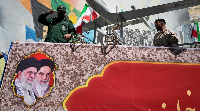 A member of Iran's Revolutionary Guard salutes while riding on a float displaying drones during the state-organized "Janfada," or "Sacrifice for Iran," military-style parade in Tehran, Iran, Friday, Sept. 18, 2026. (AP Photo/Vahid Salemi)
