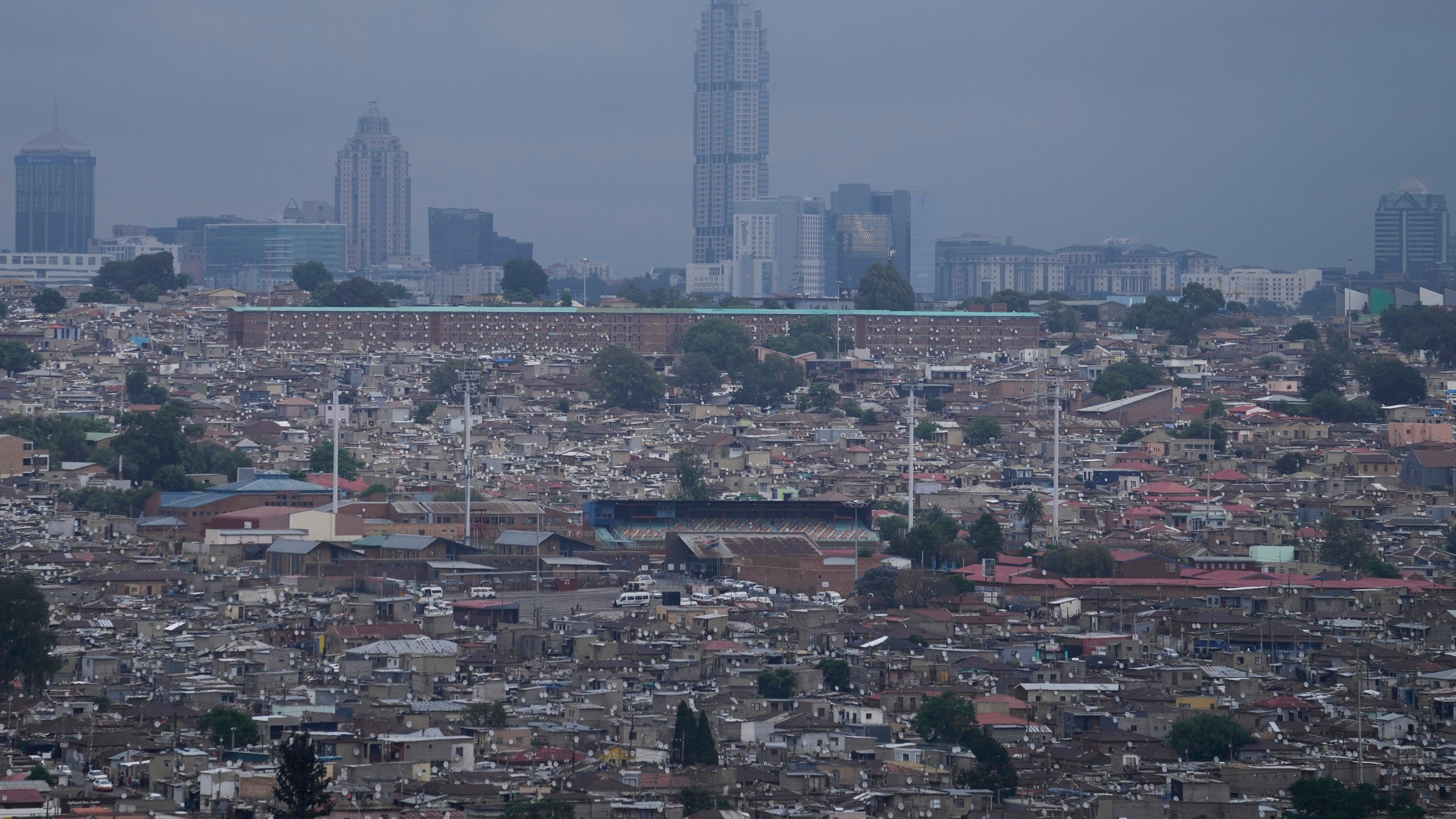 A view of Alexandra township, with the Sandton financial district in the background, in Johannesburg, South Africa, Friday, Nov. 14, 2025. (AP Photo/Themba Hadebe)