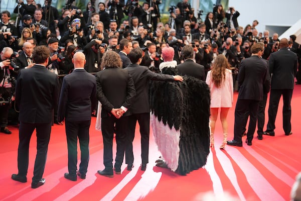 A person dressed in a bird costume, centre, poses for photographers upon arrival at the premiere of the film 'Die, My Love' at the 78th international film festival, Cannes, southern France, Saturday, May 17, 2025. (Photo by Lewis Joly/Invision/AP)