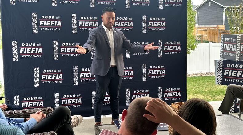 Utah State Rep. Doug Fiefia talks to Utah voters on the back deck of a house, Thursday, April 9, 2026, in Riverton, Utah. Fiefia, a Republican, has a background in technology and is running for the state senate with a pledge to tackle AI. (AP Photo/Nicholas Riccardi)