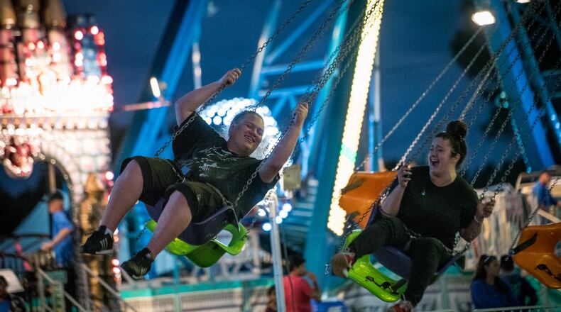 Trent Jurek, left, and Kaitlyn Concepcion ride the carnival swings during the first night of the South Florida Garlic Fest in Lake Worth on Friday, Feb. 10, 2017. Garlic Fest serves as a space for homegrown talent and a cultural showcase providing an outlet for local artists and chefs to express themselves. The festival will run until Sunday, Feb. 12, 2017. (Michael Ares / The Palm Beach Post)