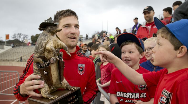 Bobby Boswell of D.C. United holds the ATX Pro Challenge trophy, an armadillo wearing a cowboy hat and toting pistols.