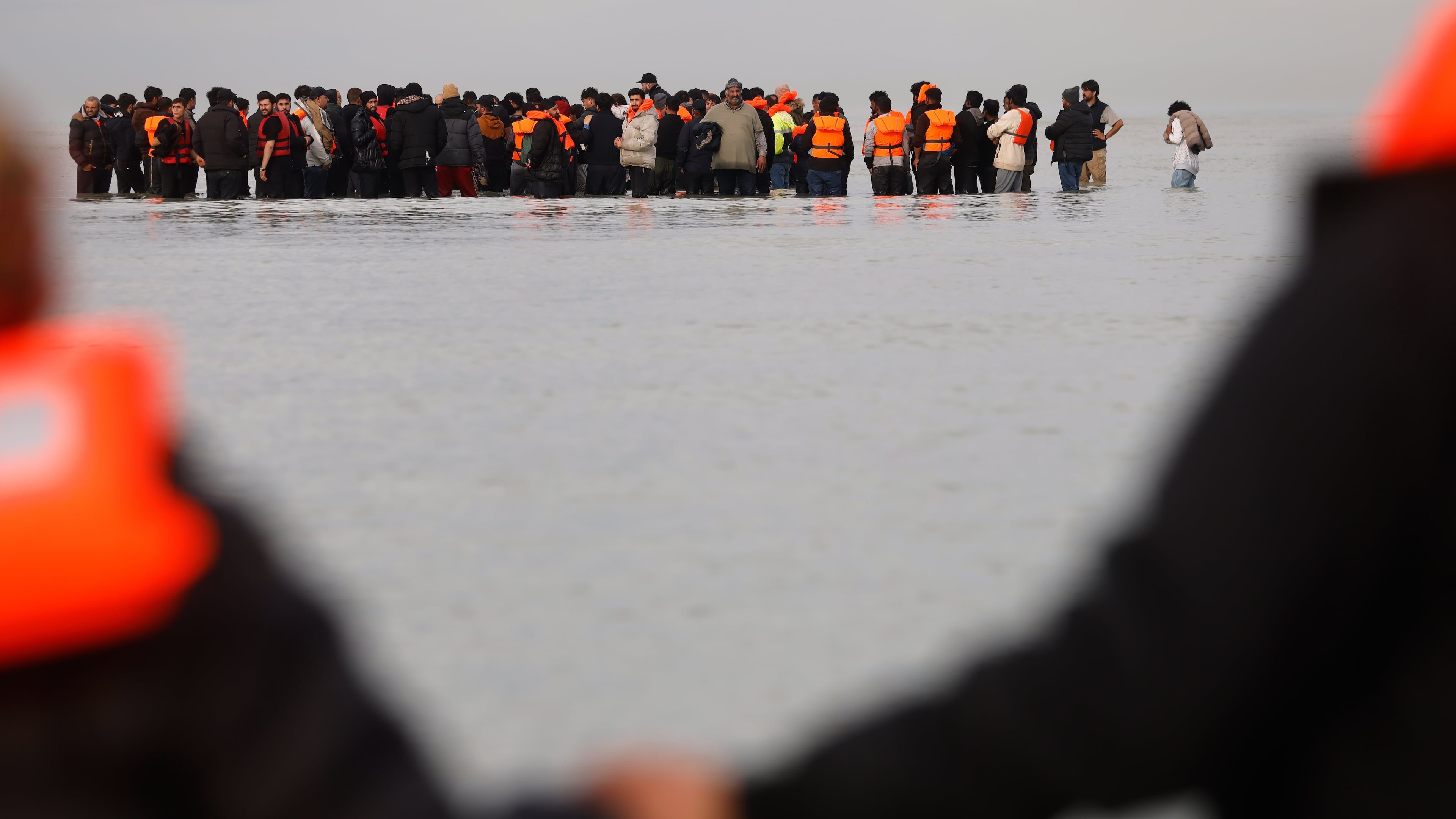 Migrants push a small boat in an attempt to reach Britain, Thursday, Nov. 6, 2025 in Gravelines, northern France. (AP Photo/Jean-Francois Badias)