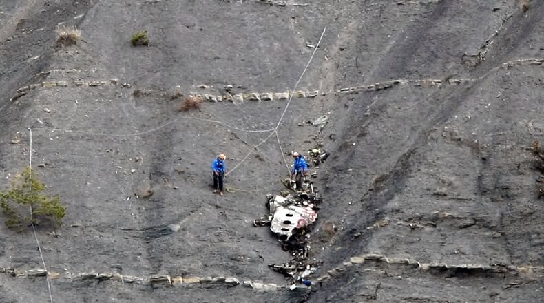 Searches go through the debris at the site of the plane crash.