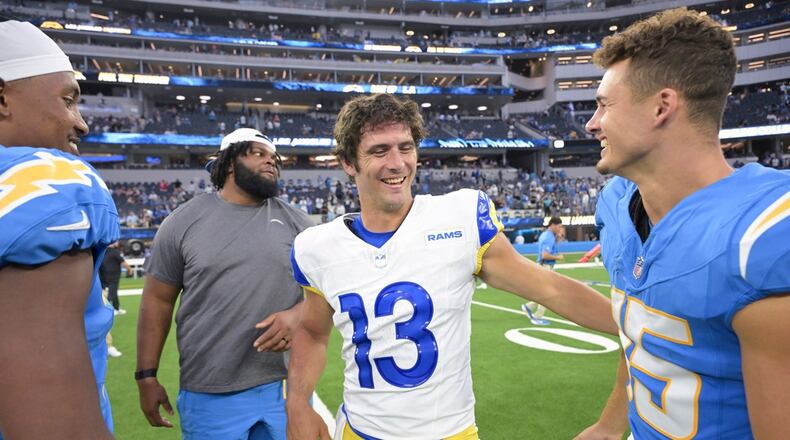 Los Angeles Rams quarterback Stetson Bennett, center, talks to Los Angeles Chargers wide receiver Ladd McConkey (15) after a preseason NFL football game Saturday, Aug. 17, 2024, in Inglewood, Calif. (AP Photo/Jayne Kamin-Oncea)