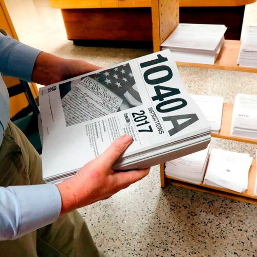 FILE- In this Feb. 15, 2018, photo, Susan Prendergast, reference supervisor at the Eudora Welty Library, in Jackson, Miss., adds additional federal tax filing information booklets on a shelf. (AP Photo/Rogelio V. Solis, File)