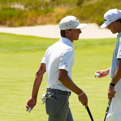 Miles Russell and Jackson Koivu walk on the 14th hole during the third round of the U.S. Open golf tournament at Shinnecock Hills Golf Club in Southampton, N.Y., Saturday, June 20, 2026.(AP Photo/Seth Wenig)