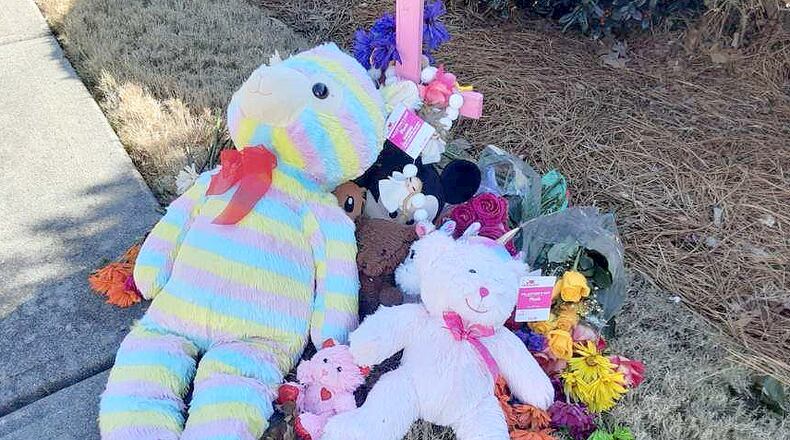 Stuffed animals and flowers are part of a memorial for a 7-year-old girl struck by a driver who didn't stop.