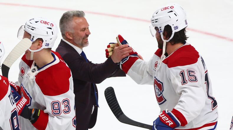 Montreal Canadiens head coach Martin St. Louis shakes hands with Montreal Canadiens center Alex Newhook (15) following the overtime period in Game 7 of a second-round NHL hockey Stanley Cup playoff series against the Buffalo Sabres, Monday, May 18, 2026, in Buffalo, N.Y. (AP Photo/Jeffrey T. Barnes)