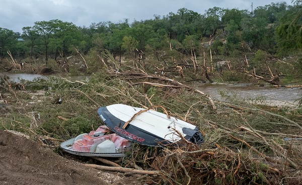 Damaged boats and debris litter the banks of the Guadalupe River near Cade Loop on Saturday, July 5, 2025, in Ingram, Texas. (AP Photo/Rodolfo Gonzalez)