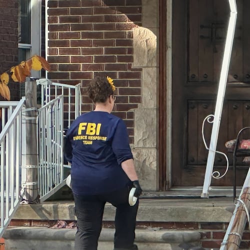 An FBI agent enters a home in a Dearborn, Mich., neighborhood on Friday, Oct. 31, 2025. (AP Photo/Mike Householder)