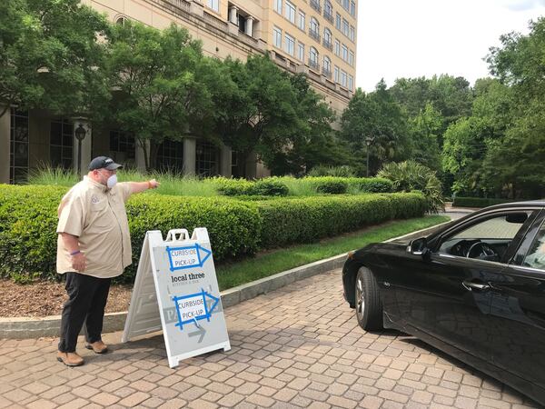 Local Three chef and partner Chris Hall directs traffic for curbside pickup at the restaurant. Ligaya Figueras/ligaya.figueras@ajc.com