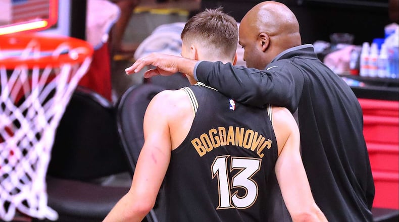 070321 Atlanta: Atlanta Hawks interim coach Nate McMillan and guard Bogdan Bogdanovic walk off the court together after losing to the Milwaukee Bucks 118-107 in game 6 of the NBA Eastern Conference Finals on Saturday, July 3, 2021, in Atlanta.   “Curtis Compton / Curtis.Compton@ajc.com”