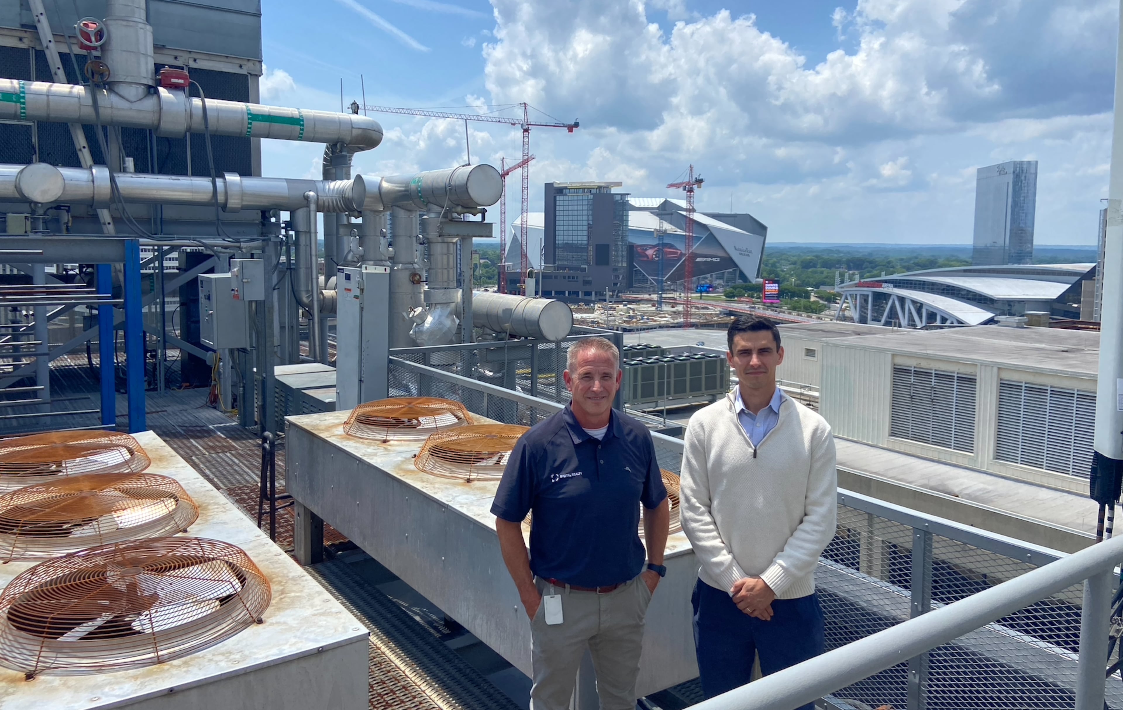 Jon Tibbitts (left) and Andrew Alves, of Digital Realty, pose atop the roof of 56 Marietta, a century-old building that serves as a downtown data center. (Zachary Hansen/AJC)