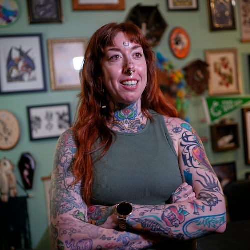 Tattoo artist Mischa Ostberg talks with a visitor at the Ghost Rose Tattoo parlor, Nov. 3, 2025, in Ellsworth, Maine. (AP Photo/Robert F. Bukaty)