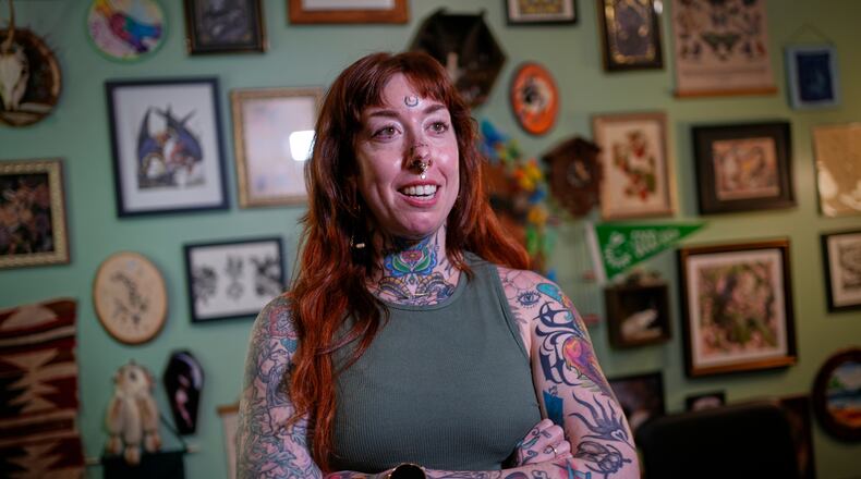 Tattoo artist Mischa Ostberg talks with a visitor at the Ghost Rose Tattoo parlor, Nov. 3, 2025, in Ellsworth, Maine. (AP Photo/Robert F. Bukaty)