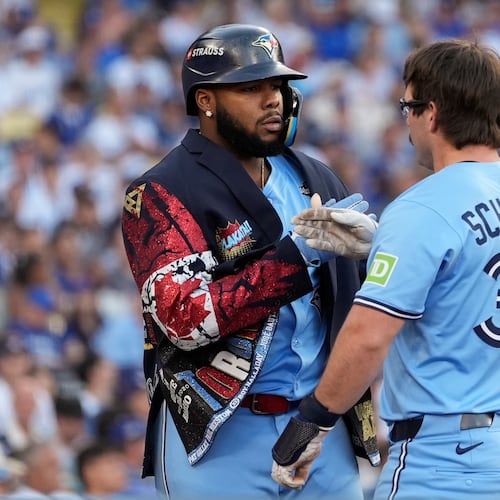 Toronto Blue Jays' Davis Schneider (36) celebrates with Vladimir Guerrero Jr. after their back-to-back home runs during the first inning in Game 5 of baseball's World Series against the Los Angeles Dodgers, Wednesday, Oct. 29, 2025, in Los Angeles. (AP Photo/Ashley Landis)