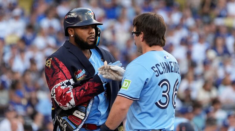 Toronto Blue Jays' Davis Schneider (36) celebrates with Vladimir Guerrero Jr. after their back-to-back home runs during the first inning in Game 5 of baseball's World Series against the Los Angeles Dodgers, Wednesday, Oct. 29, 2025, in Los Angeles. (AP Photo/Ashley Landis)