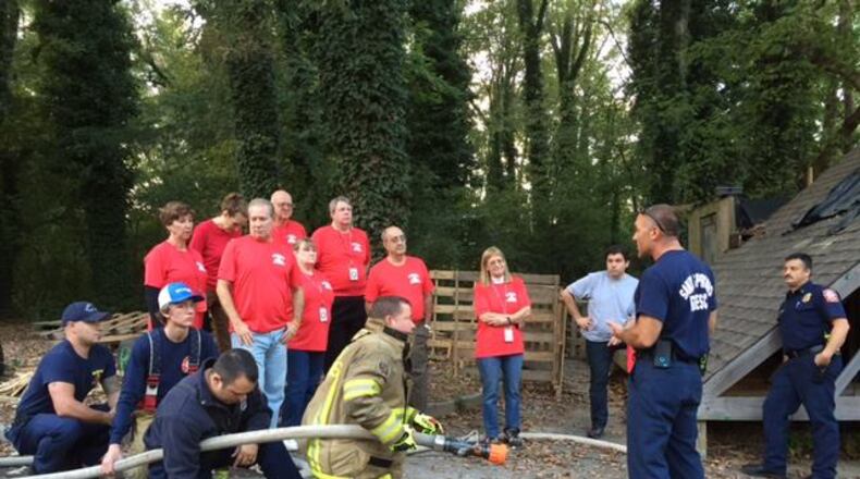 Participants in a past Sandy Springs Citizens Fire Academy learn about hose deployment from members of the Sandy Springs Fire Department. CITY OF SANDY SPRINGS