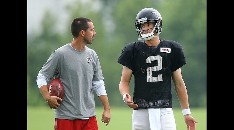 Falcons offensive coordinator Kyle Shanahan confers with quarterback Matt Ryan during team practice Tuesday in Flowery Branch. Curtis Compton/www.ajc.com