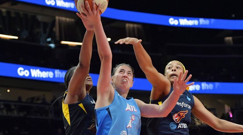 Atlanta Dream guard Maite Cazorla (center) shoots as Indiana Fever forward Stephanie Mavunga (left) tries to block her shot at State Farm Arena in Atlanta on Wednesday, June 19, 2019. HYOSUB SHIN / HSHIN@AJC.COM