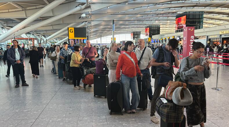 Passengers wait in line at Heathrow Airport in London, during an air traffic control problem that disrupted travel across Britain. (Jonathan Brady/PA via AP)