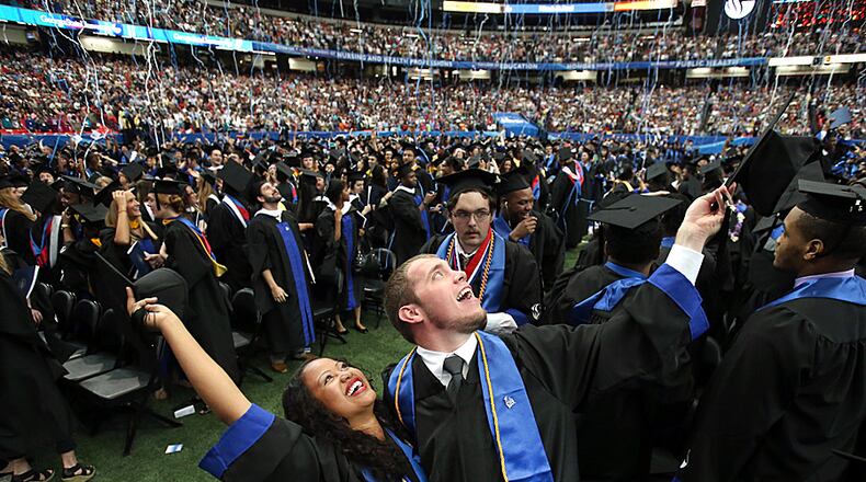 Georgia State University undergraduates Stephanie-Joy Rhoden, of Miami, Fla., left, and her fiance Jon-Michael Drain, of Douglasville, celebrate at the conclusion of the Spring 2014 Commencement at the Georgia Dome Saturday afternoon, May 10, 2014. Rhoden and Drain, both journalism majors met while at GSU.