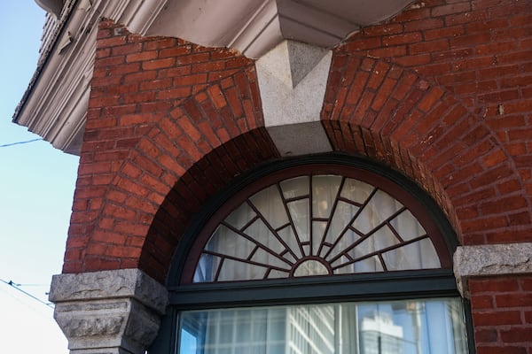 A close look at the exterior of 125 Edgewood Ave., which features red brick, granite and curved windows. (Abbey Cutrer/AJC)