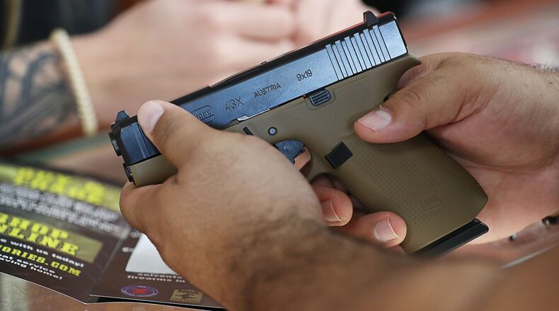A customer looks at a handgun at the Kissimmee, Florida location of The Armories, on Thursday, Dec. 31, 2020. (Ricardo Ramirez Buxeda/ Orlando Sentinel/TNS)