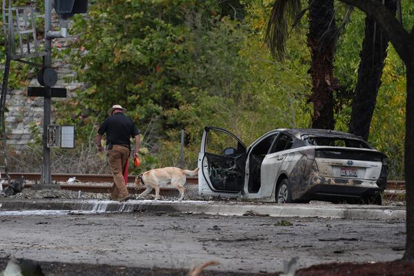 Emergency personnel respond to the area where a small plane crashed on the railroad tracks beneath the overpass near Interstate 95 in Boca Raton, Fla., on Friday, April 11, 2025. (AP Photo/Marta Lavandier)