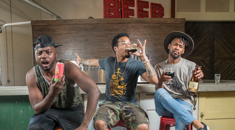 Nappy Roots group members Melvin Adams (from left) W. Hughes (center) and Blake German pose for a portrait with samples of their craft beer at Monday Night Brewing in the West End neighborhood of Atlanta. The group is launching a new beer, “Kentucky Mud.” ALYSSA POINTER/ALYSSA.POINTER@AJC.COM