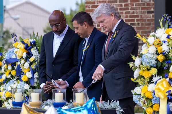 (L-R) U.S. Sen. Raphael Warnock, D-Ga., Barrow County Superintendent Dallas LeDuff, and U.S. Rep. Mike Collins, R-Jackson, light candles at a vigil at Jug Tavern Park in Winder on Friday, Sept. 6, 2024. A 14-year-old Apalachee High School student is accused of shooting and killing two fellow students and two teachers and injuring nine others at the Barrow County high school on Wednesday. (Arvin Temkar / AJC)