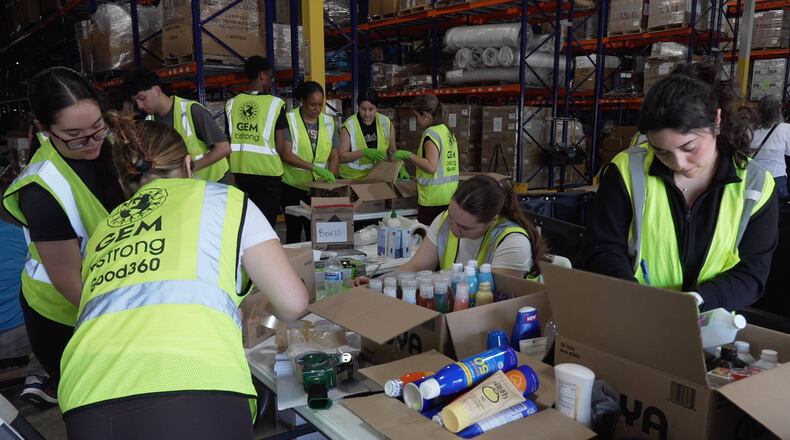 Volunteers are seen packaging supplies, Thursday, June 25, 2026, in Doral, Fla. (AP Photo/Cody Jackson)