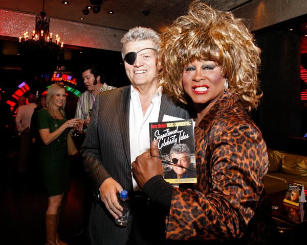 Las Vegas Review-Journal columnist Norm Clarke, left, stands with Tina Turner impersonator, Larry Edwards, during a book signing party for Clarke's book at the Playboy Club inside Palms hotel-casino, Nov. 12, 2008, in Las Vegas. (Duane Prokop/Las Vegas Review-Journal via AP)