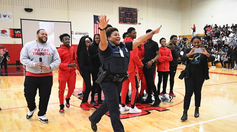Atlanta Public Schools police officer L.J. Williamson is surprised by her son, U.S. Army specialist Shakir Aquil, who is home for the first time in two years. The reunion took place during a pep rally at Therrell High School on Friday, Jan. 17, 2020, in Atlanta. JOHN AMIS